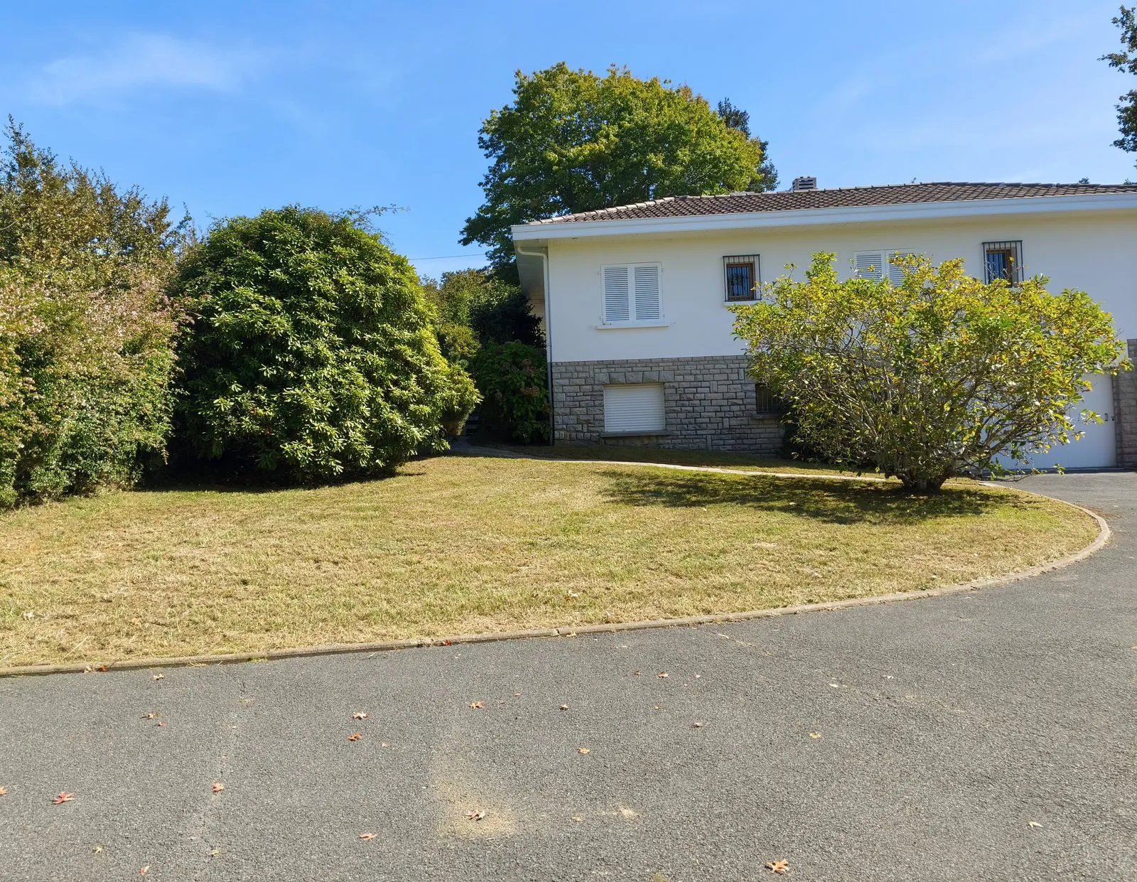 Le même terrain tondu et net devant la maison, après débroussaillage